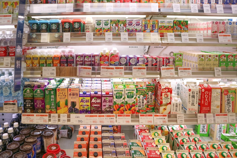 A full selection of different juice and cold drink brands in a grocery store.