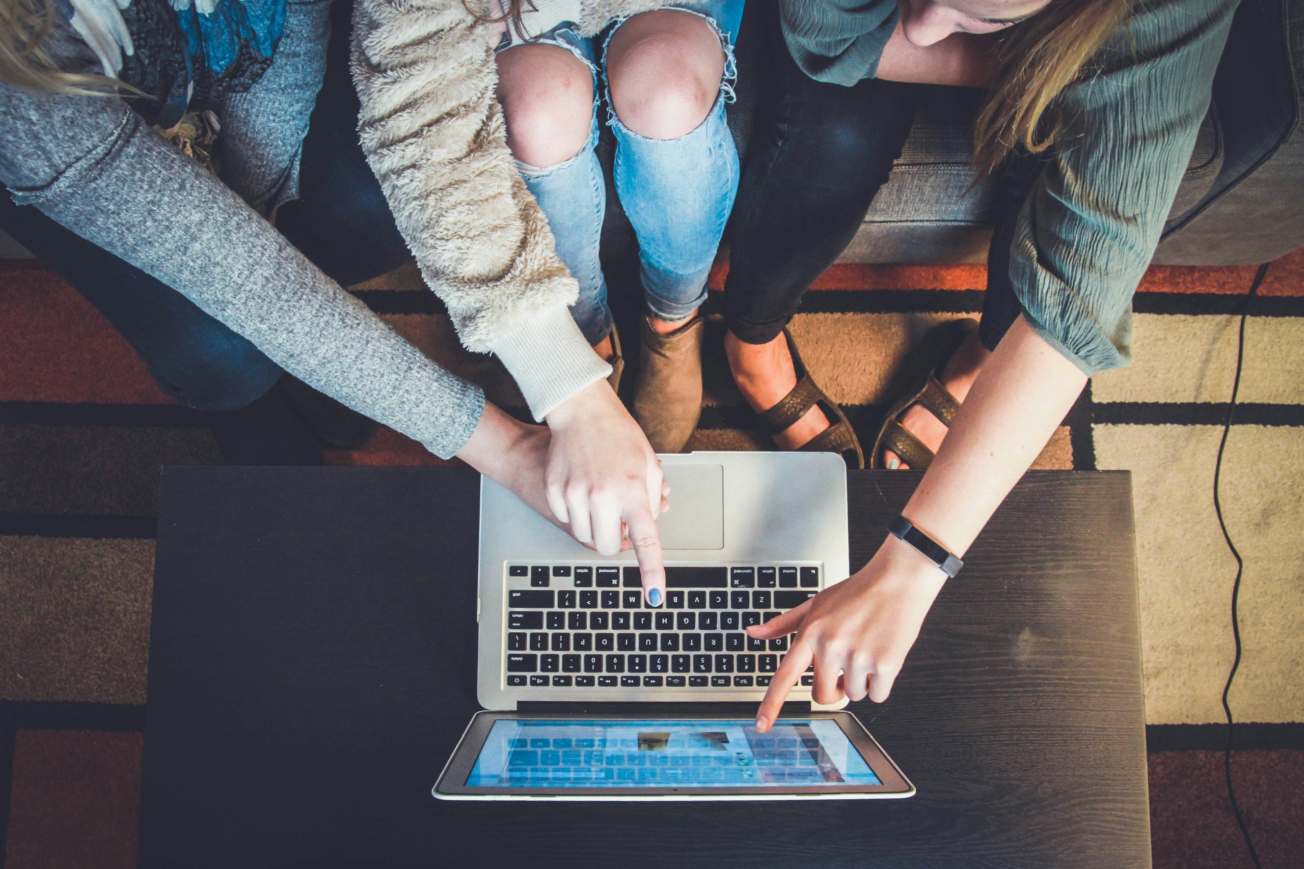 A group of people pointing at a laptop while doing market research