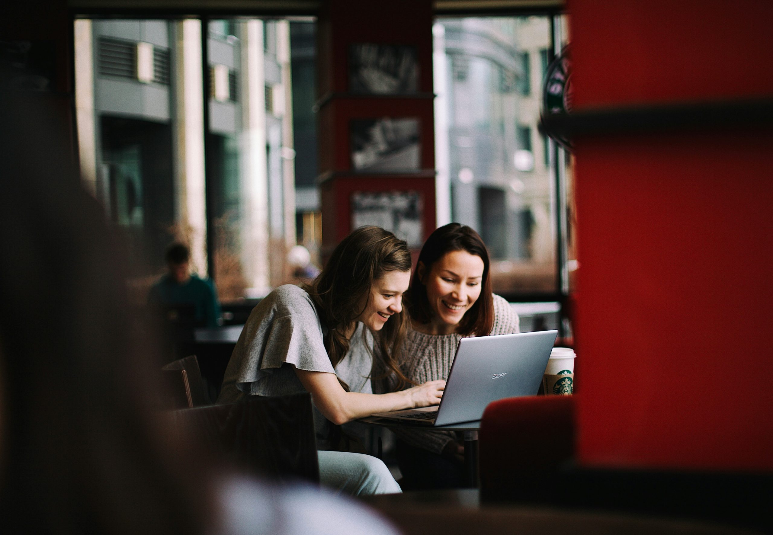 Two colleagues working on interval scale data in a coffee shop