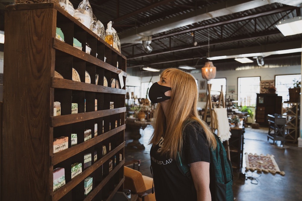 A woman in a shop choosing between tea brands.