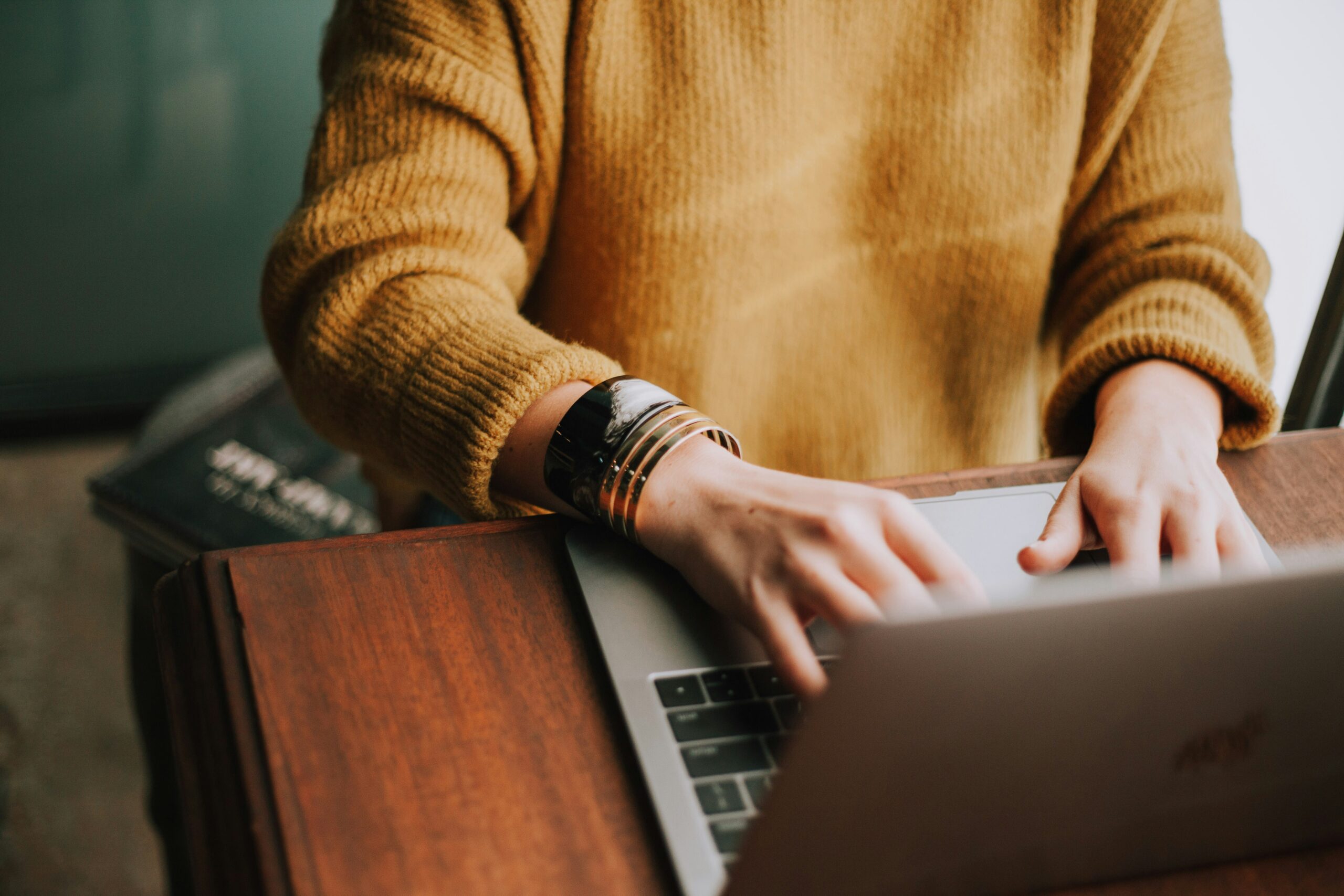 Woman typing out qualitative market research questions on her laptop
