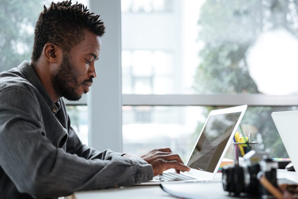 Man working on a computer to detect and remove bots from survey responses